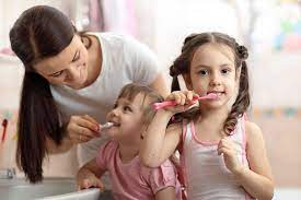 madre y hijas cepillando los dientes